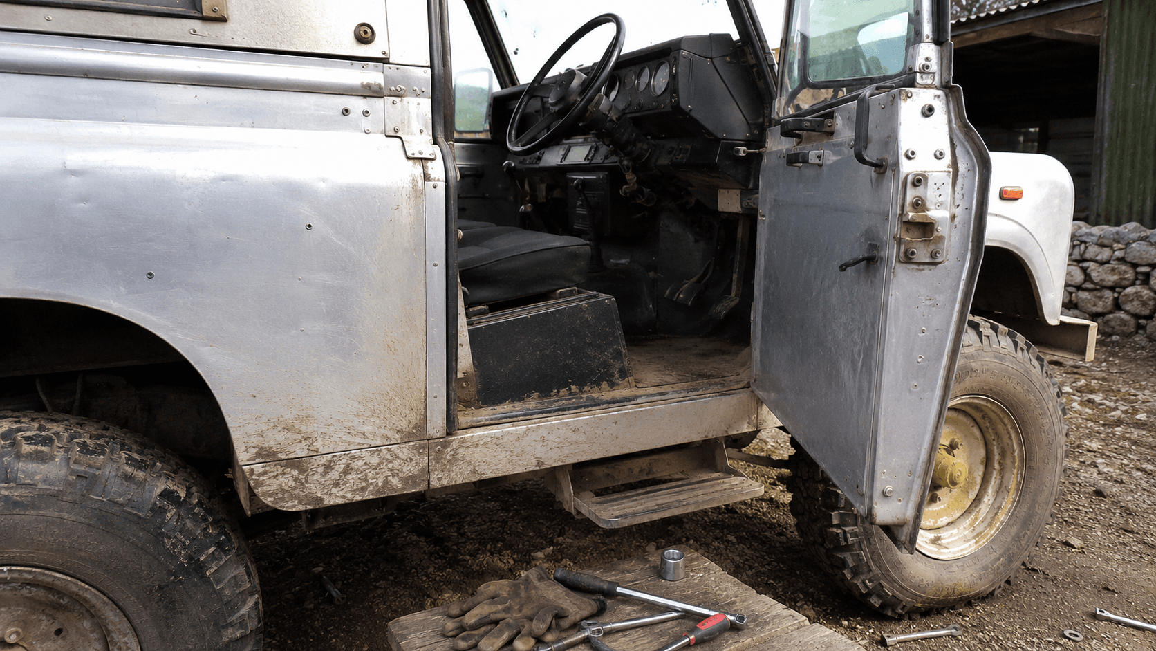 經典 Defender 車身鉸鏈、工具、泥土與修復痕跡的自然光細節