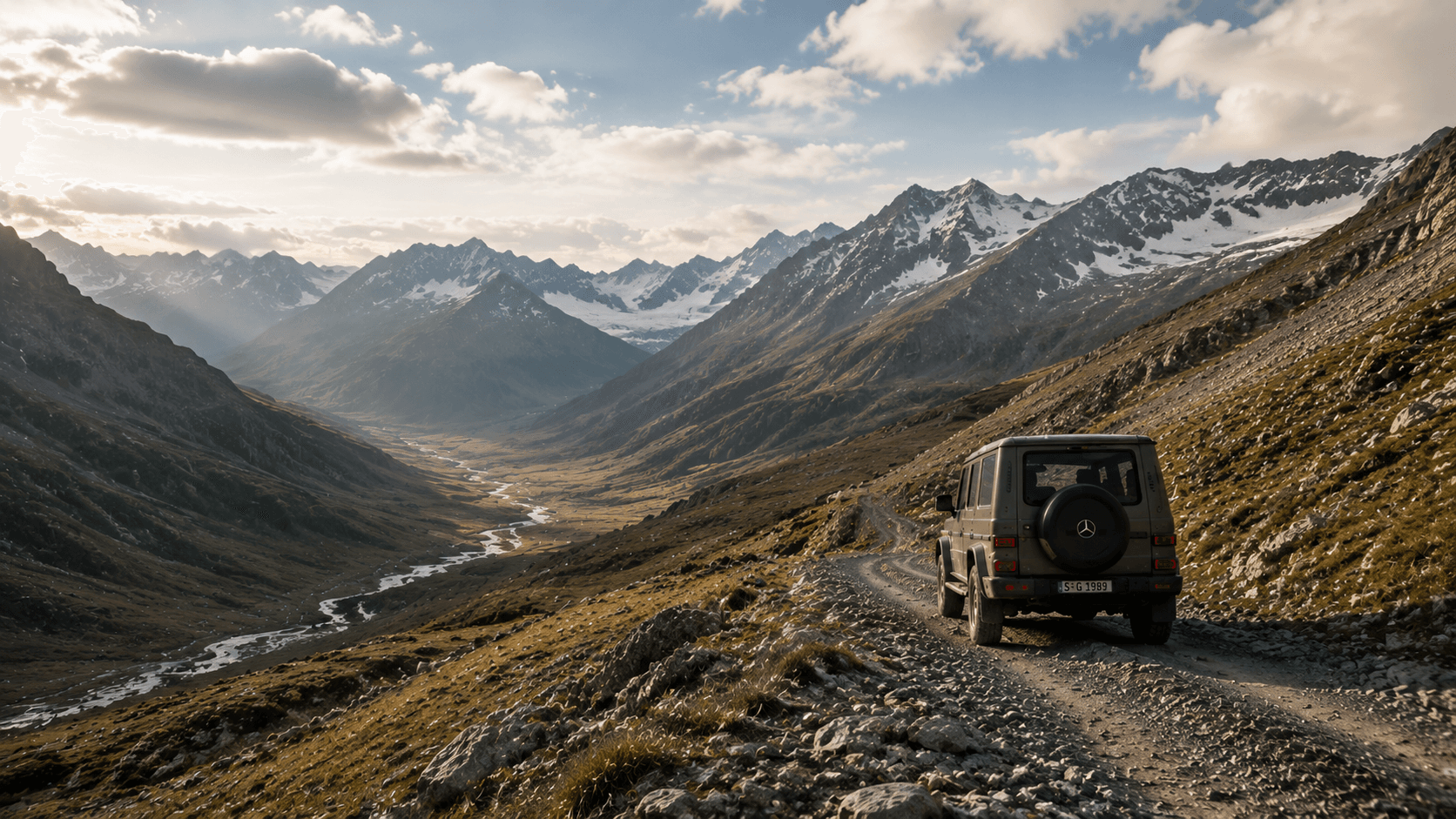 現代 Mercedes G-Class 沿寬闊高山河谷中的碎石道路駛向遠方